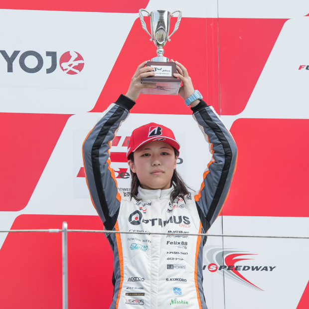 表彰式でカップを掲げる専属ドライバー(第1戦3位)